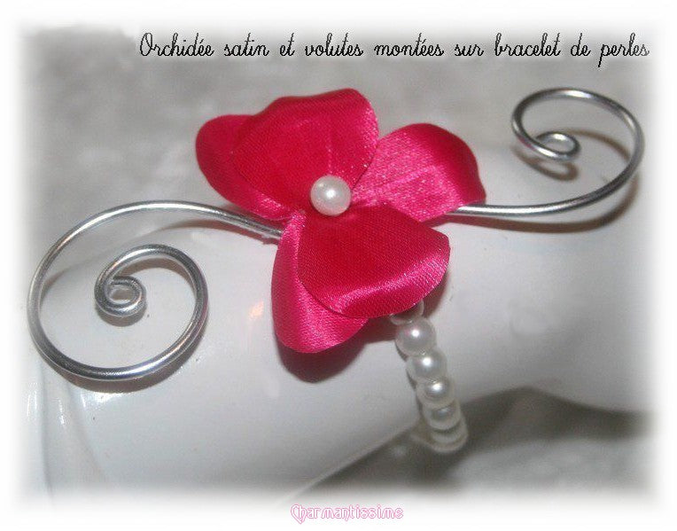 Bracelet mariage petite fleur orchidée fuchsia en satin et perles nacrées blanches sur volutes d'alu argent pour mariée bohème chic